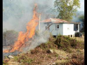 A bush fire threatens this house in Llandewey, western St. Thomas. This photo was taken in May, 2015. (Photo: Ian Allen/Gleaner)